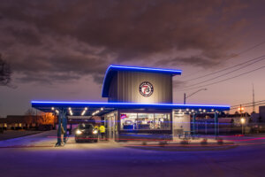 Exterior 7Brew food service building at night with lights architecture by SGA Design Group.